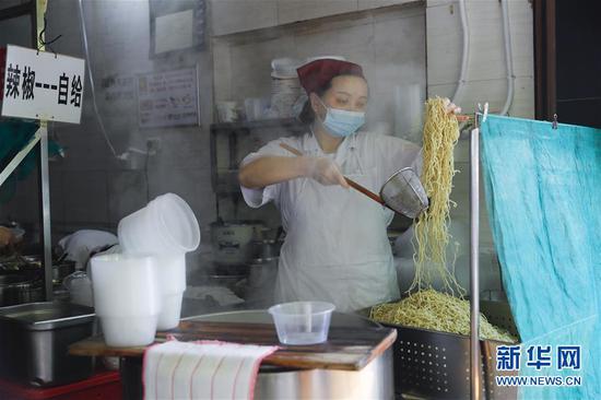 4月22日，武漢市糧道街的家陽“趙師傅”天天紅油熱干面店廚師在制作熱干面。新華社記者 沈伯韓 攝