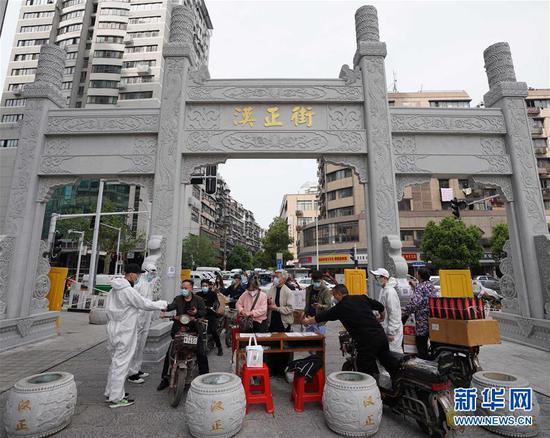  4月16日，進(jìn)出武漢漢正街步行街的人員在掃描健康碼。新華社記者 王毓國(guó) 攝